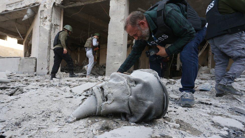 A photographer at the site of a damaged medical centre after alleged Azerbaijani shelling in Stepanakert in Nagorno-Karabakh, 28 October 2020