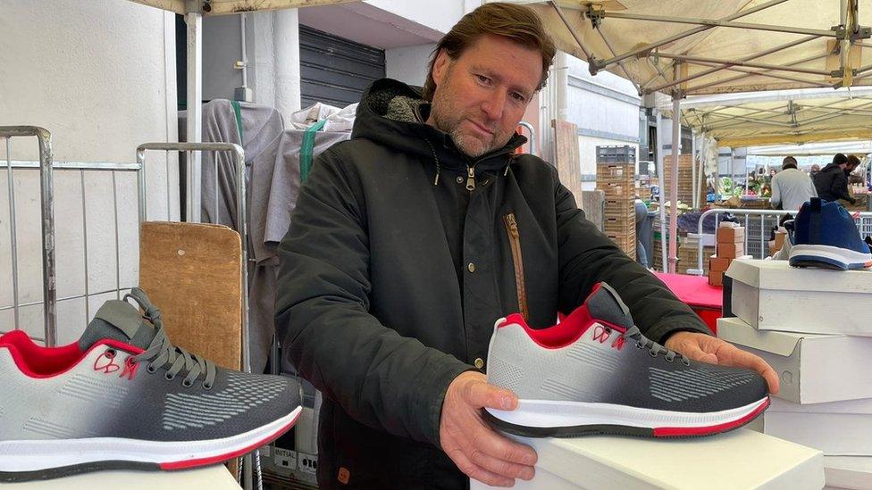 Market seller Thierry with shoes