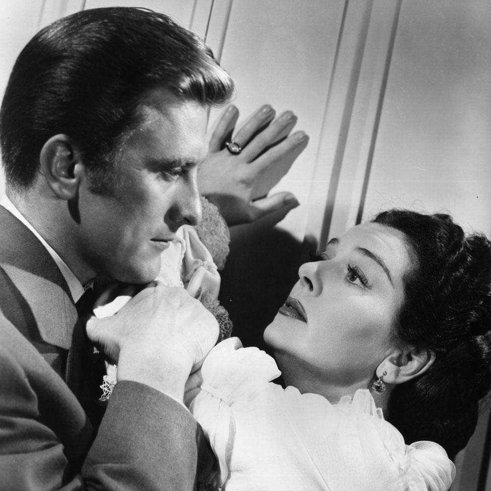 Actress Rosalind Russell fends off the advances of her admirer Kirk Douglas, in the film Mourning Becomes Electra.