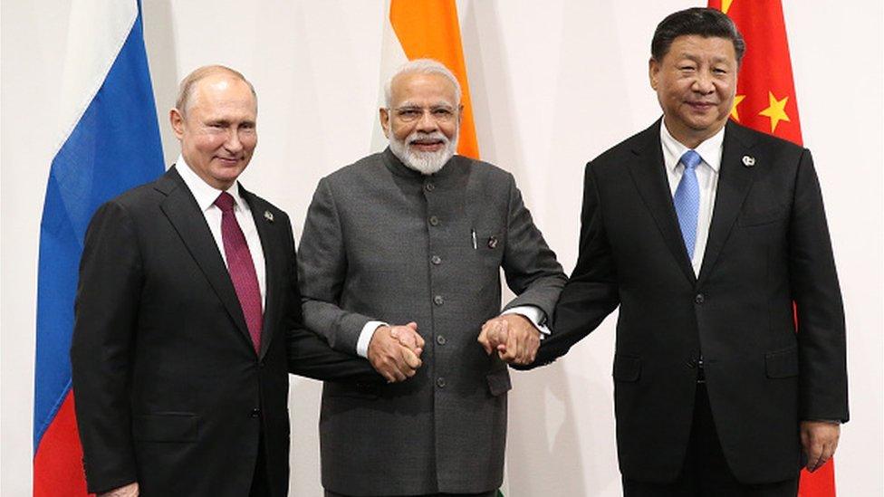 Russian President Vladimir Putin (L), Indian Prime Minister Narendra Modi (C) and Chinese President Xi Jinping (R) pose for a group photo prior to their trilateral meeting at the G20 Osaka Summit 2019 on June 28, 2019 in Osaka, Japan.