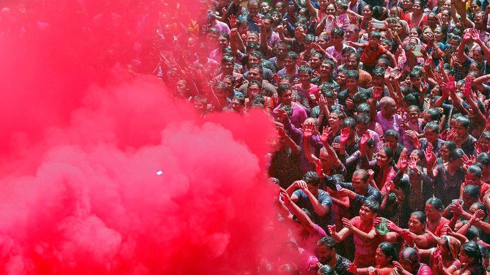 A group of people are sprayed with colours during celebrations in Ahmedabad