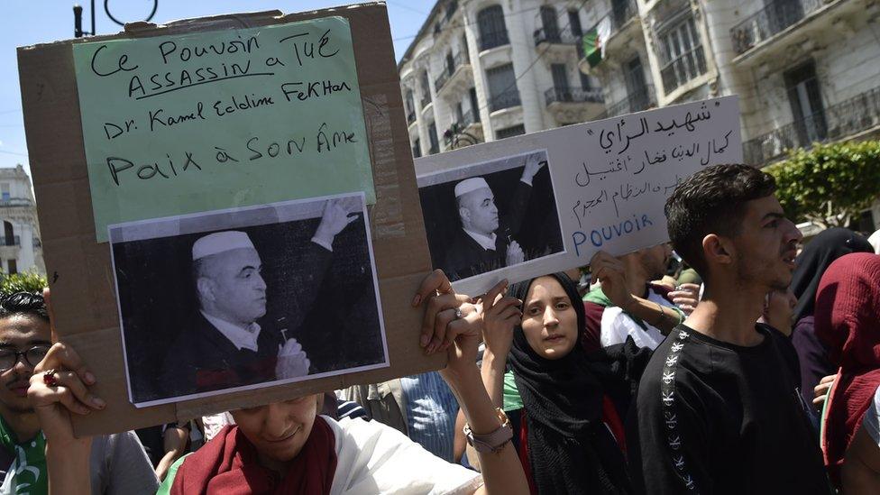 Algerian students hold a sign following the reported death of political activist Kamel Eddine Fekhar, on 28 May 2019