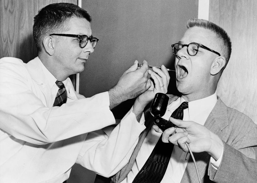 Dr. Harry L. Williams squirts LSD from a syringe into the mouth of Carl Curt Pfeiffer, M.D., Ph.D. (1908-1988) at Emory University in Atlanta, Georgia, 1955. Dr. Pfeiffer performed experiments in behavior control for the CIA, researching the effects of LSD on prisoners in Atlanta and Bordentown, N.J. in the 1950s and 1960s.