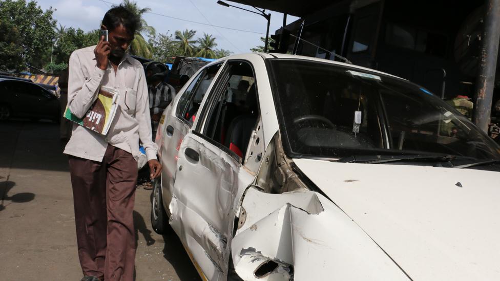 Man looks at crashed car