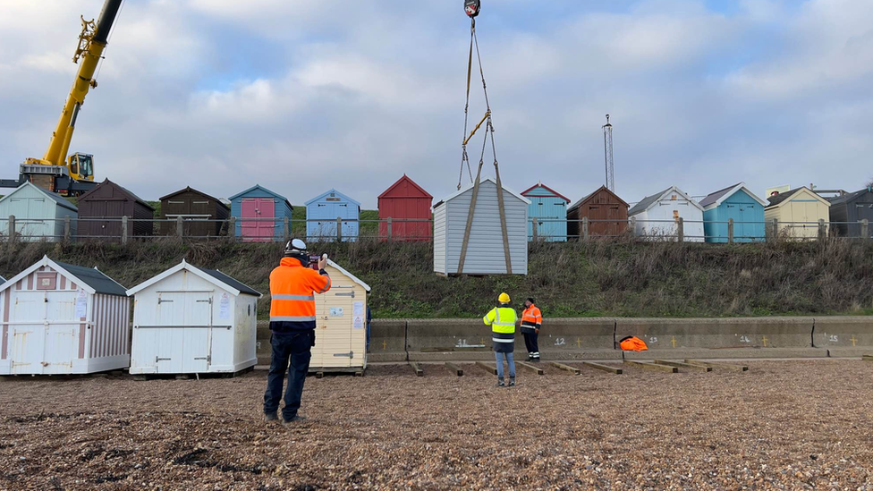 A crane lifting up one of the beach huts at Felixstowe beach