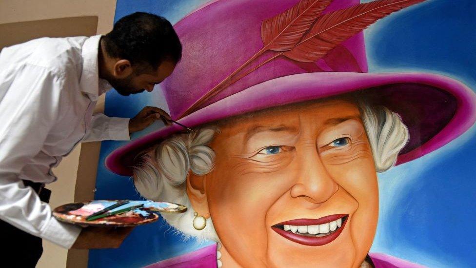 Man painting mural of the queen