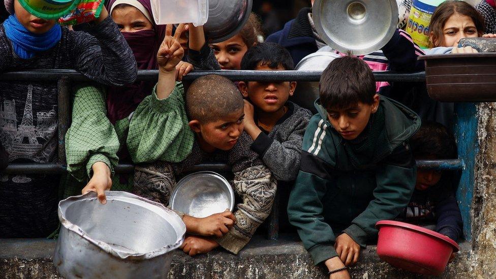 Children waiting to collect food aid in Gaza