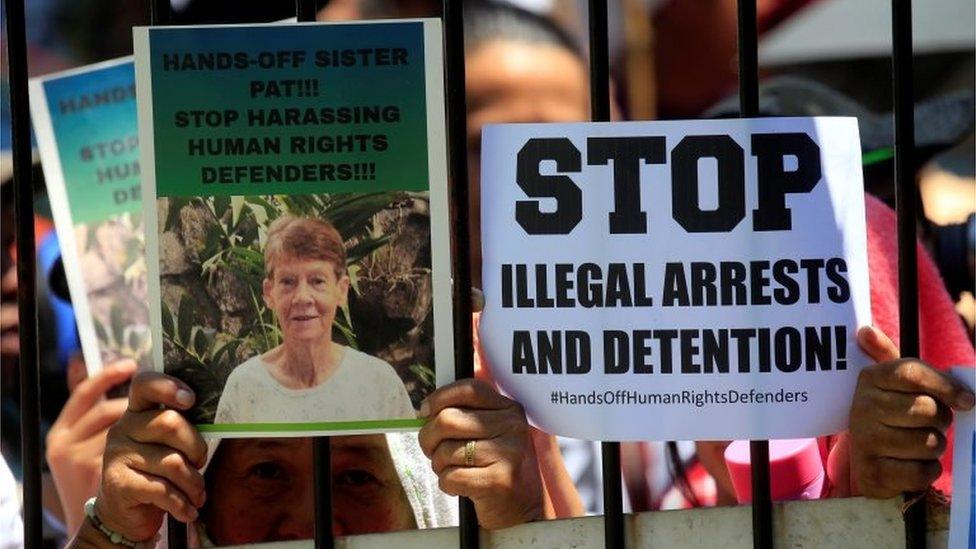 Supporters of Australian nun Patricia Fox, 71, hold placards while waiting for her release outside of the Bureau of Immigration headquarters in Metro Manila, Philippines April 17, 2018.