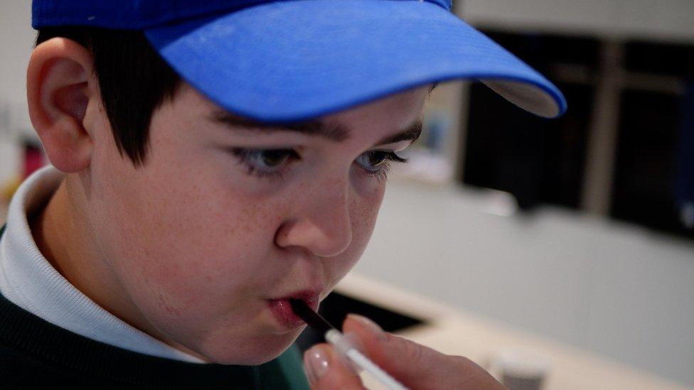 Alfie with a medicine syringe in his mouth