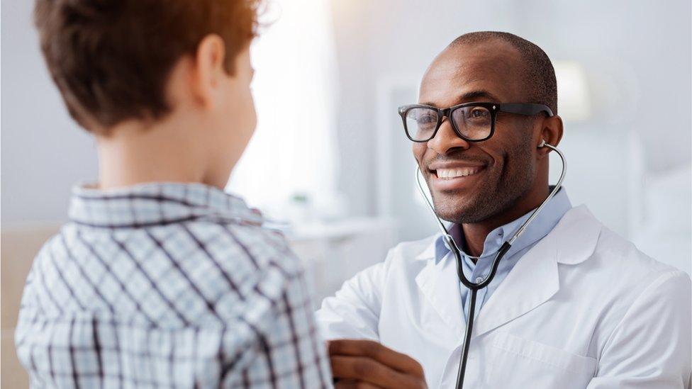 Doctor checks a boy's heartbeat