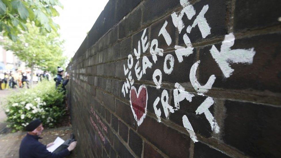 An anti-fracking protester writes messages on a wall in Lancashire