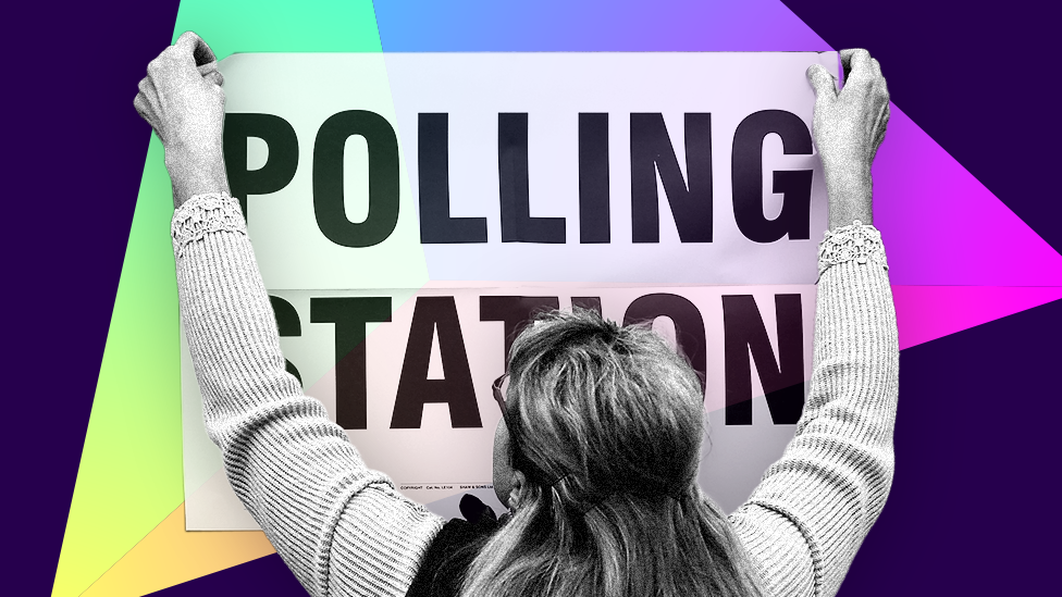 A woman holding a polling station sign