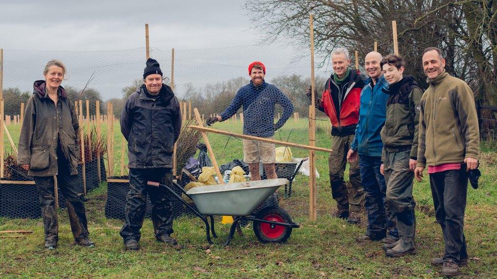 A team working on the project with wheelbarrows and spades