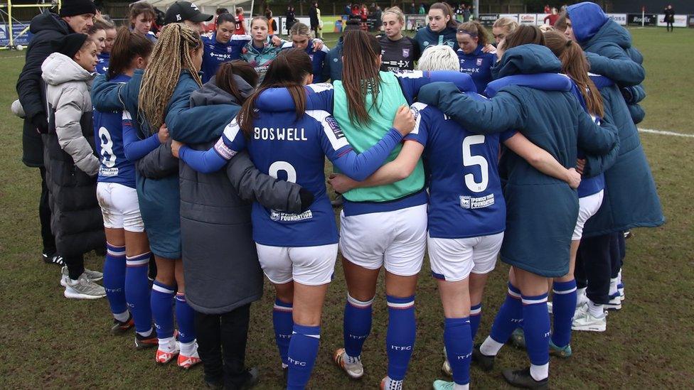 an Ipswich Town Women team huddle on the pitch