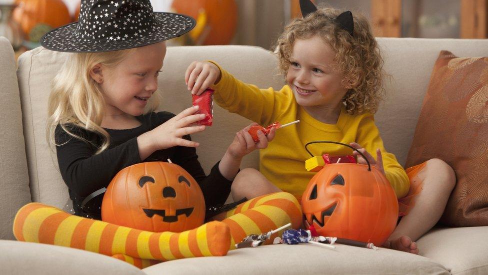Kids exchanging sweets on sofa