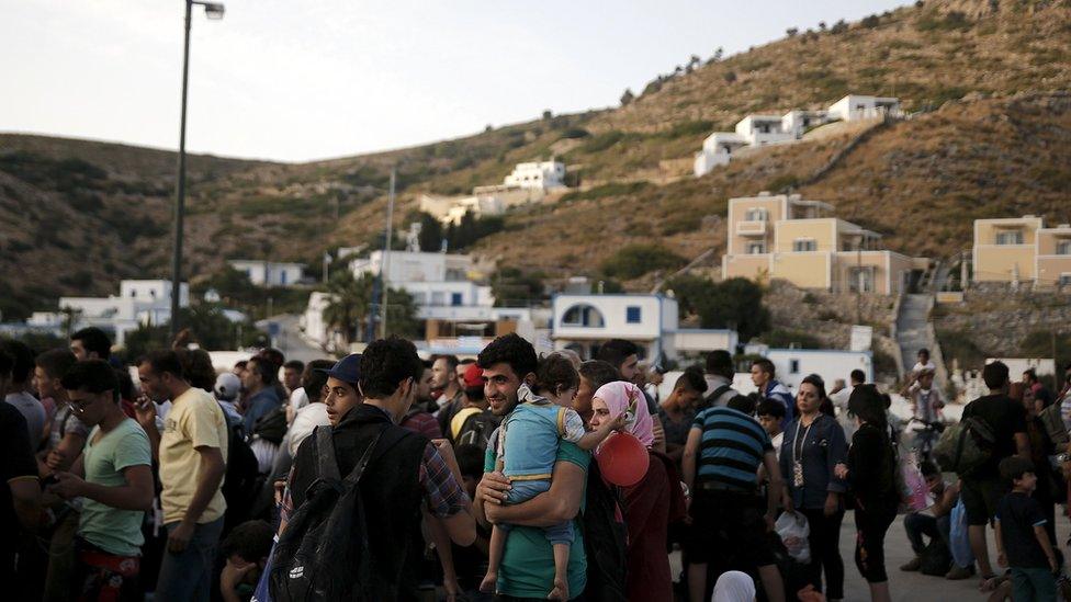 Refugees and migrants wait to board a passenger ship heading to the island of Samos, on the eastern island of Agathonisi, Greece, September 10, 2015.