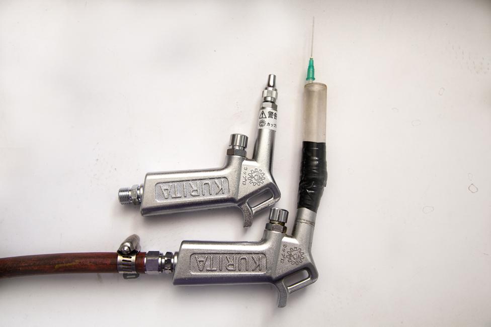 A spray gun modified in house for the precise locations of leaks by attaching a syringe needle.