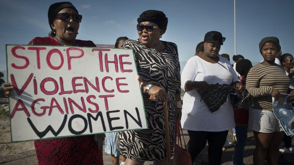 Women hold signs during a protest against ongoing violence against women, in Gugulethu, on May 21, 2016, about 20 Km from the centre of Cape Town.