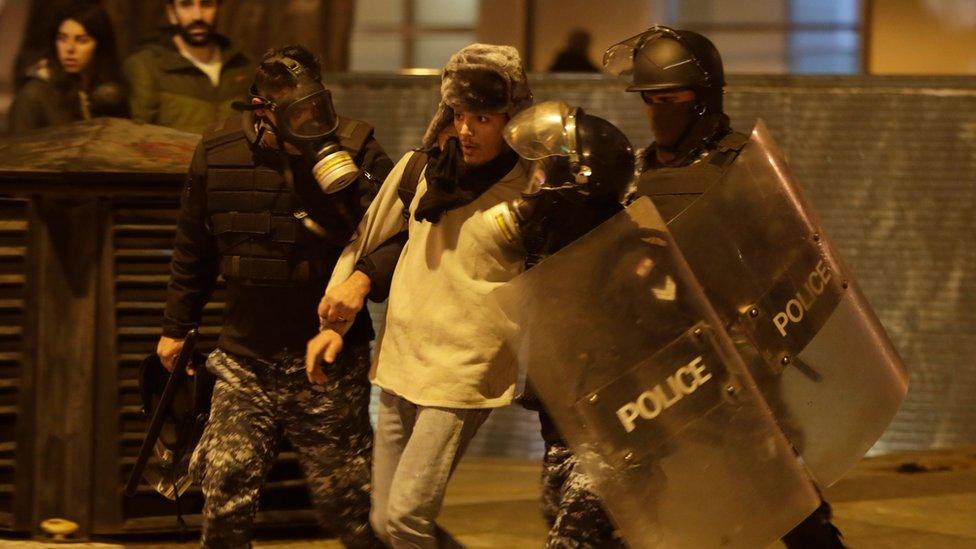 Riot police detain an anti-government demonstrator during clashes in the capital Beirut on 14 December