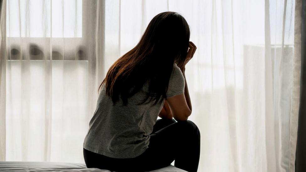 Woman sitting on bed