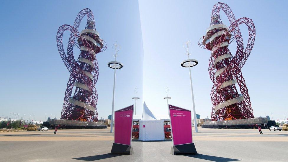 The ArcelorMittal Orbit, designed by Anish Kapoor and Cecil Balmond is reflected in a polished art installation within the Olympic Park in London in 2012