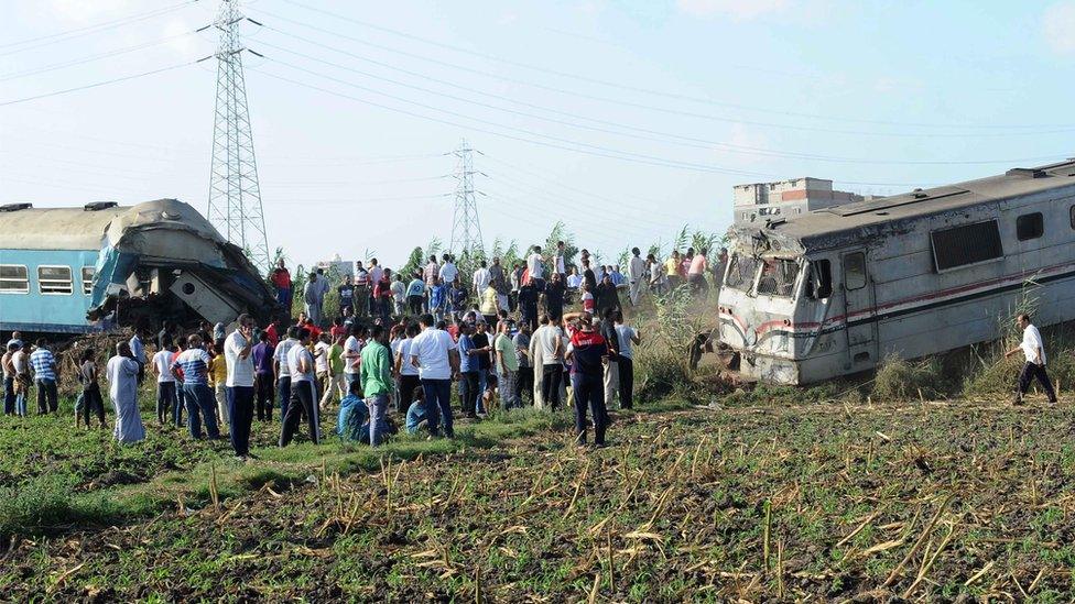 People gather at the site of a train collision in the area of Khorshid, in Egypts Mediterranean city of Alexandria