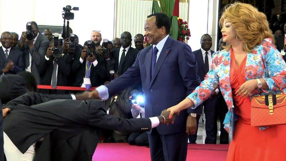 This video grab image created on February 8, 2017 shows Cameroonian national football team players perform a "deep bow" to President Paul Biya (L) and his wife Chantal Biya in Yaounde, following their 2-1 victory over Egypt in the finals of the 2017 Africa Cup of Nations in Libreville, Gabon.