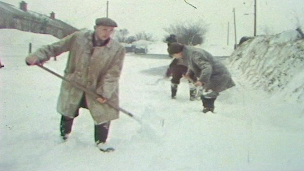 People shovel snow from the ground