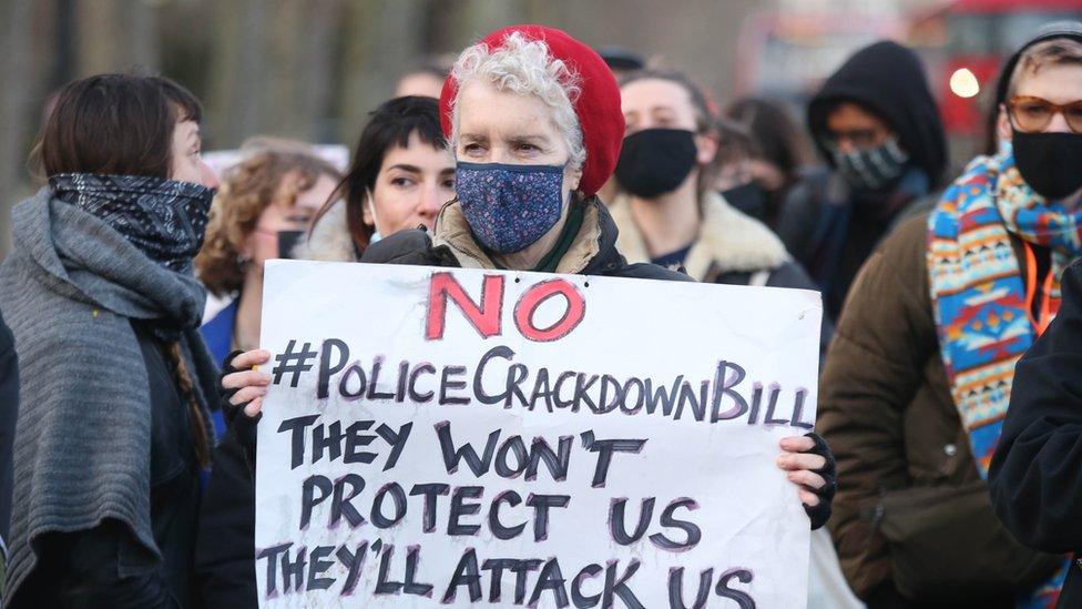 Protester holds a banner outside Scotland Yard