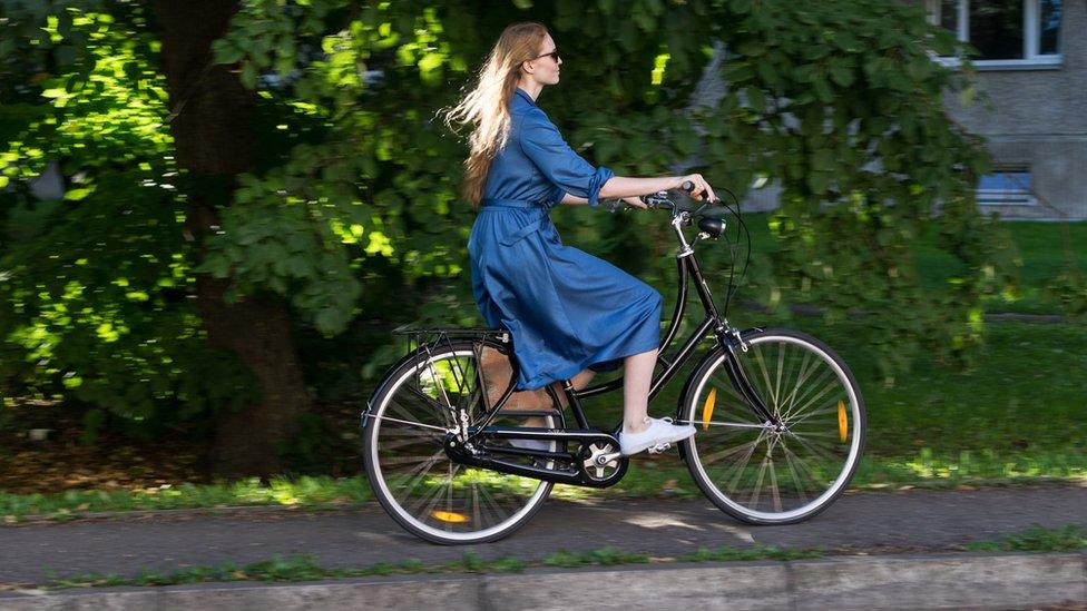 Woman cycling on path