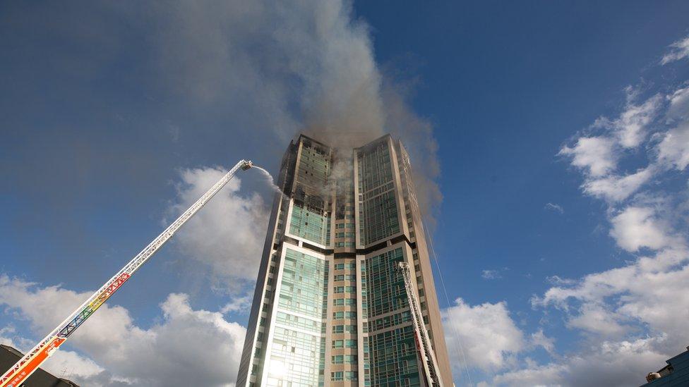 Firefighters extinguish a fire at an apartment building in Ulsan, South Korea, 09 October 2020.