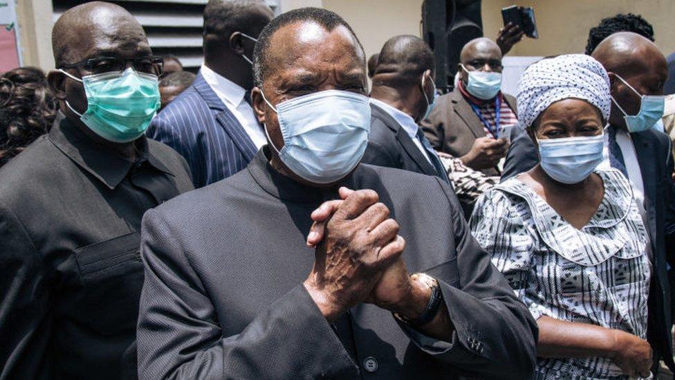 Incumbent Congo President Denis Sassou Nguesso (C) greets officials after casting his ballot in Brazzaville on March 21, 2021.