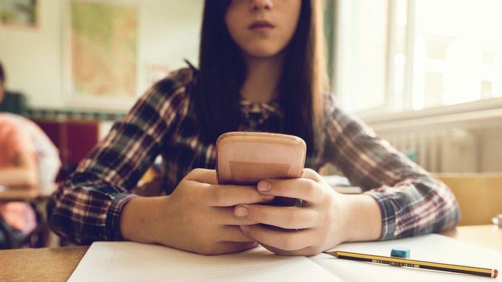 Schoolgirl using mobile phone, file pic