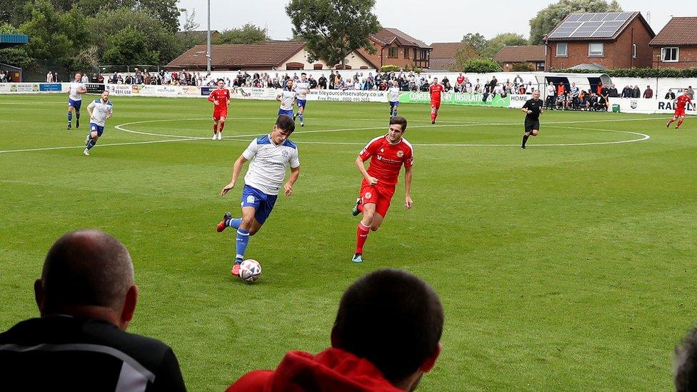 A general view of play is seen as fans watch on during the The FA Cup First Round Qualifying match between Bury AFC and North Shields