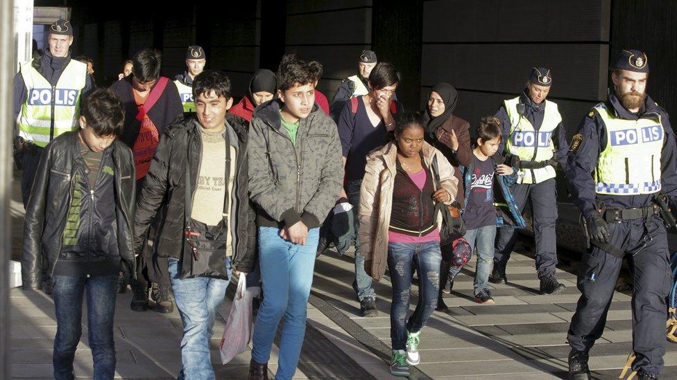 A group of migrants, coming off an incoming train, are seen next to police on the platform at the Swedish end of the bridge between Sweden and Denmark, in Hyllie district, Malmo November 12, 2015.