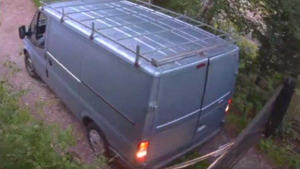 Van reversing into a gate