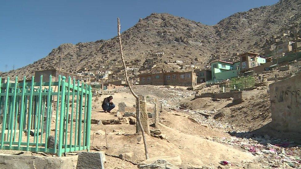 Nowruz tending the graves of his family at a cemetery in Kabul