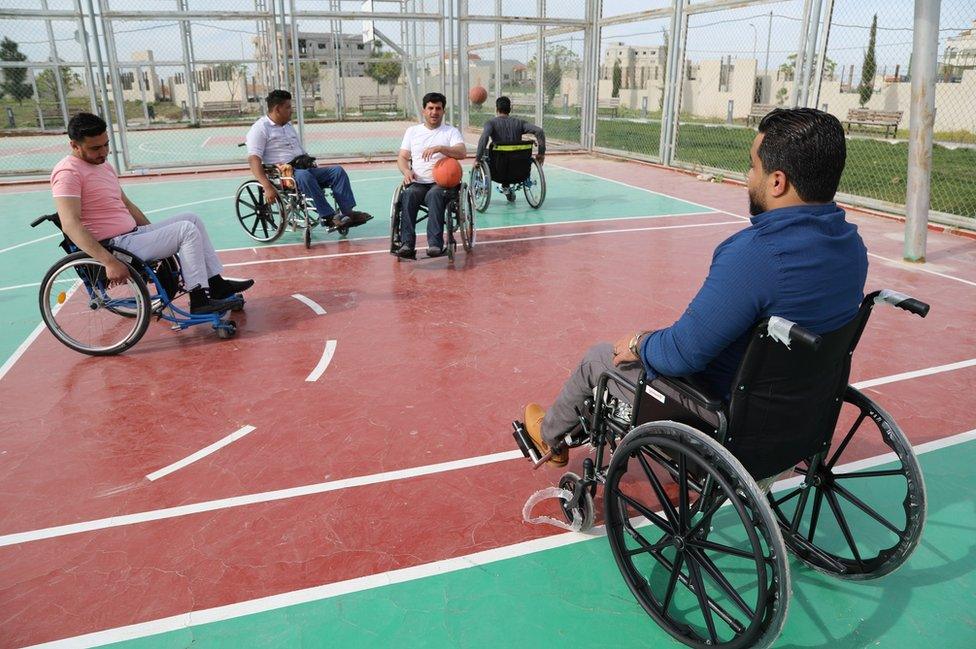 Men play basketball on the pitch.