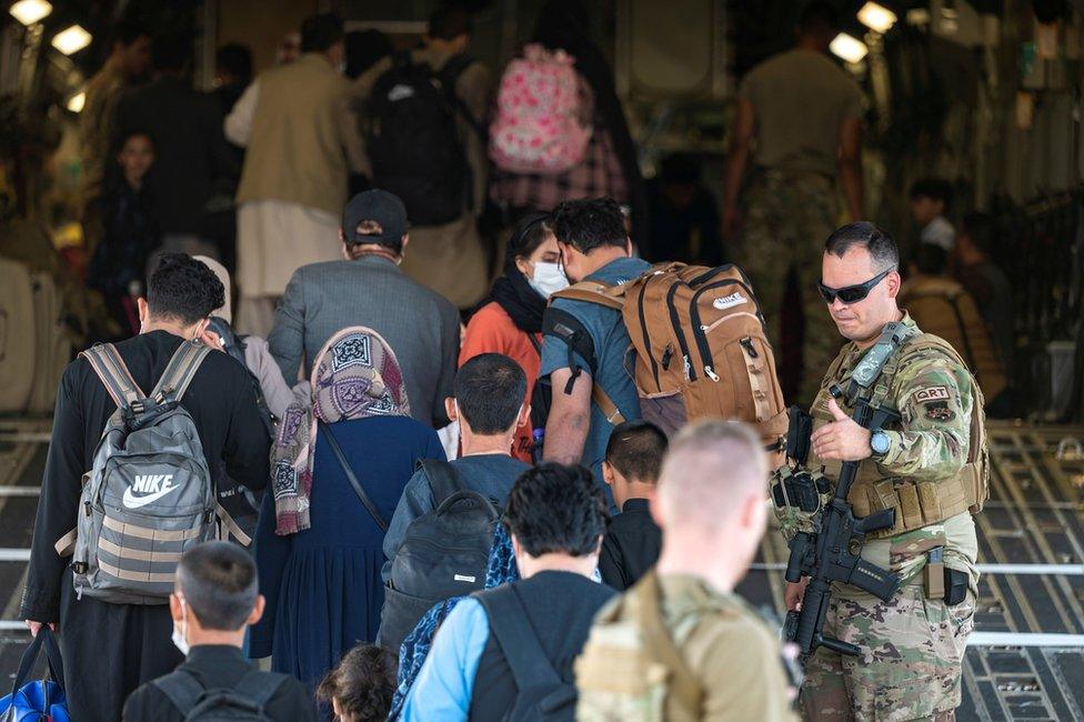 U.S. Air Force Airmen guide qualified evacuees aboard a U.S. Air Force C-17 Globemaster III at Hamid Karzai International Airport (HKIA), Afghanistan, August 24, 2021