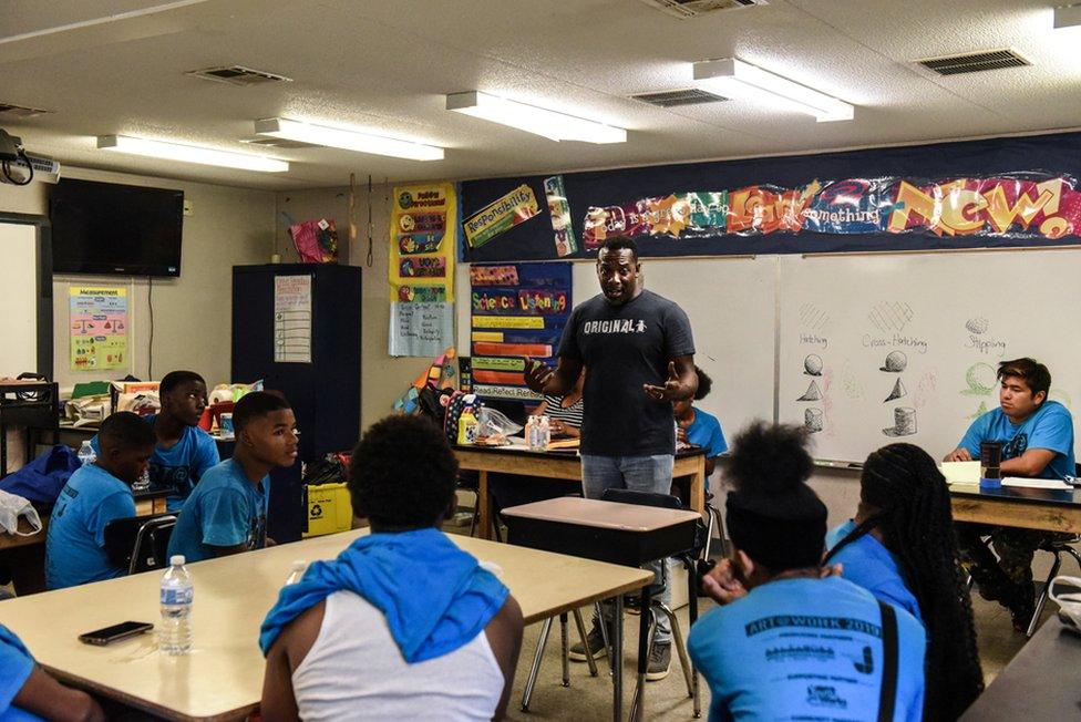 Derrick Chase from an organisation called Stand Up Baltimore speaks with teenagers at a YouthWorks site in the Curtis Bay section of Baltimore, Maryland, USA. 29 July 2019.