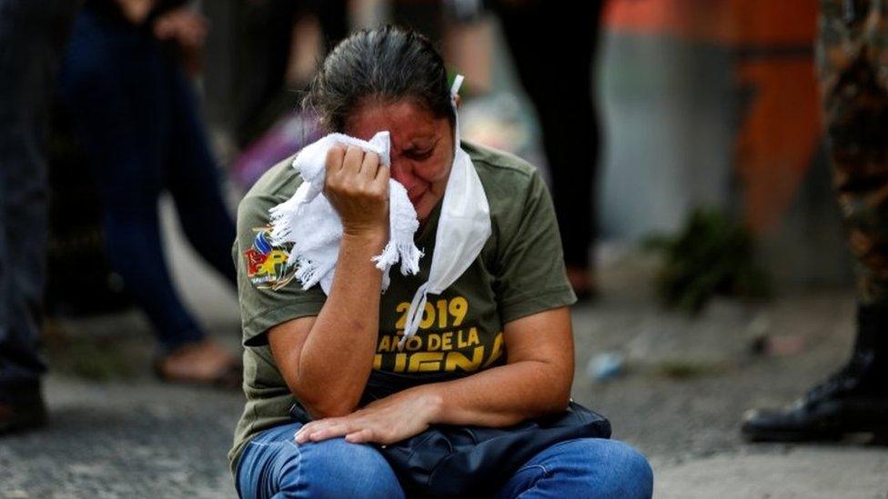 A relative reacts as police investigators collect evidence at a crime scene where a private security guard was purported killed by gang members, as the government undertakes steadily stricter measures to prevent the spread of the coronavirus disease (COVID-19), in San Martin, El Salvador April 26, 2020