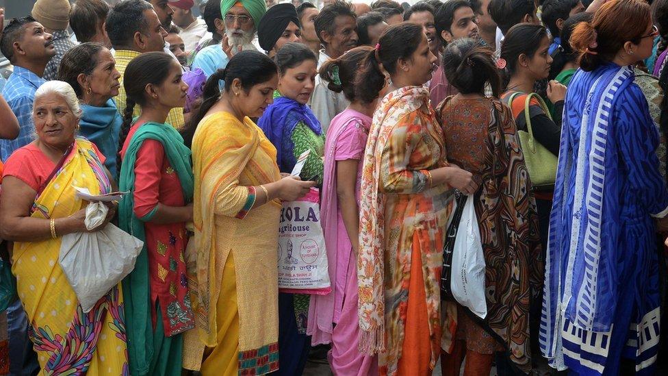 Indian bank customers wait to deposit 500 and 1000 Indian currency notes at a bank in Amritsar on November 10, 2016.