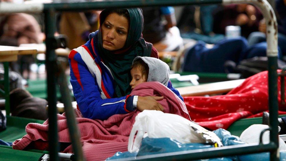 A woman tends a child at a migrant registration centre in Passau, Germany October 8, 2015.