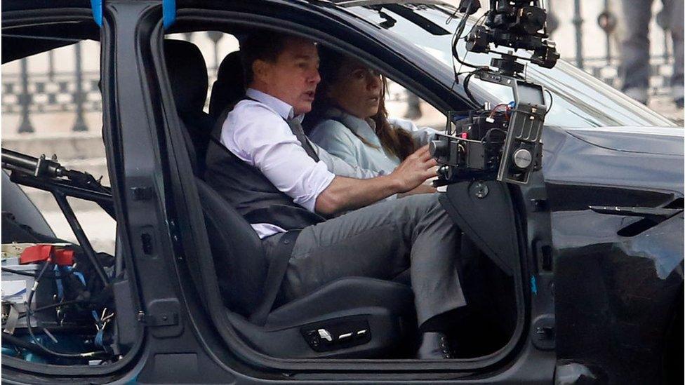 Tom Cruise and Hayley Atwell handcuffed together filming a chase with cars on the set of the film Mission: Impossible 7 in Piazza Venezi, Rome