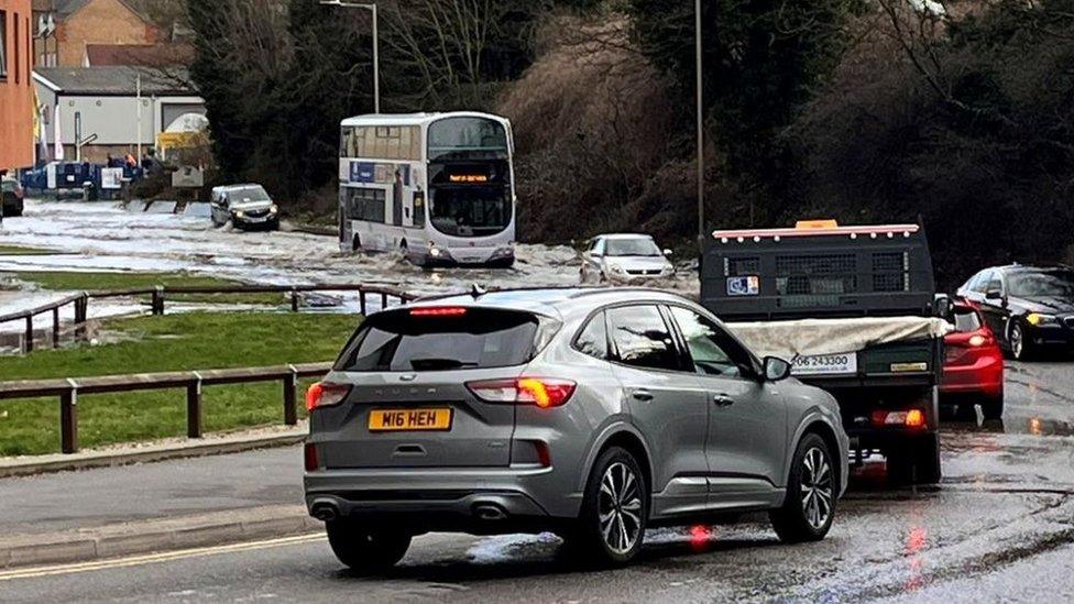 Cars queue as they approach a flooded Haven Road