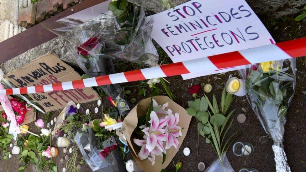 Flowers and candles laid outside the house of the murdered woman