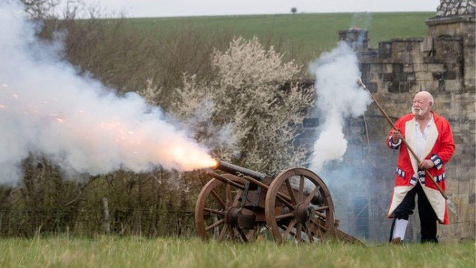 Mr Mead in costume firing a cannon