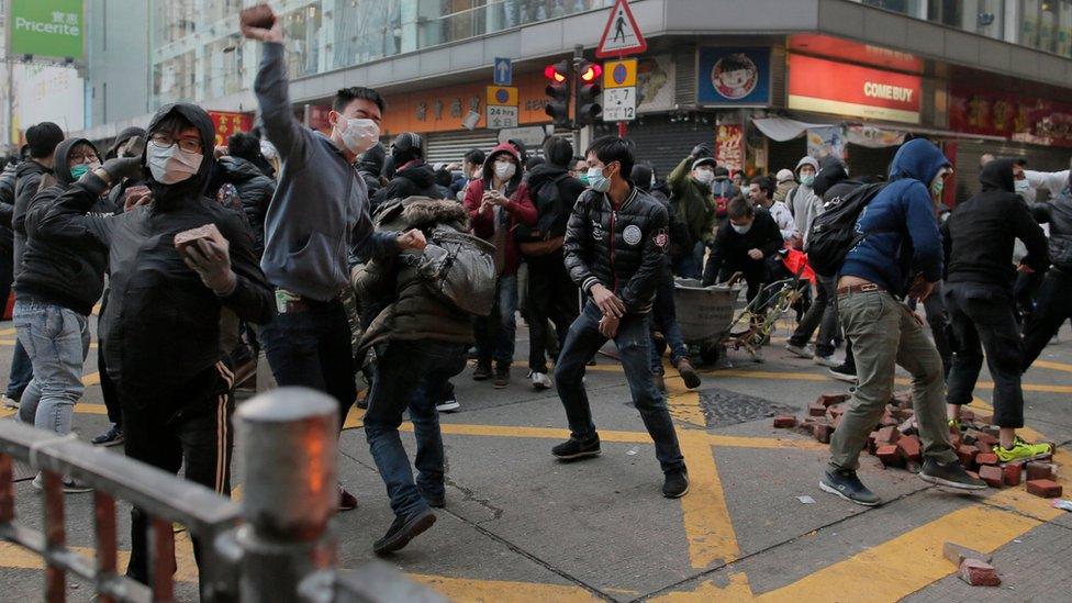 Protesters throwing bricks and other objects towards the police