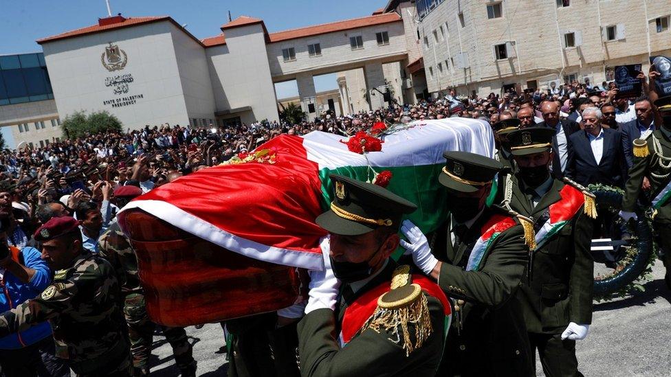 Palestinian security forces carry the coffin of Shireen Abu Aqla during a memorial ceremony outside the Palestinian Authority's headquarters in Ramallah, in the occupied West Bank (12 May 2022)