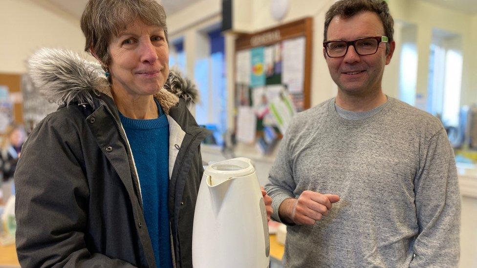 Jenny Gwynne, holding broken kettle, with Olivier Dunard